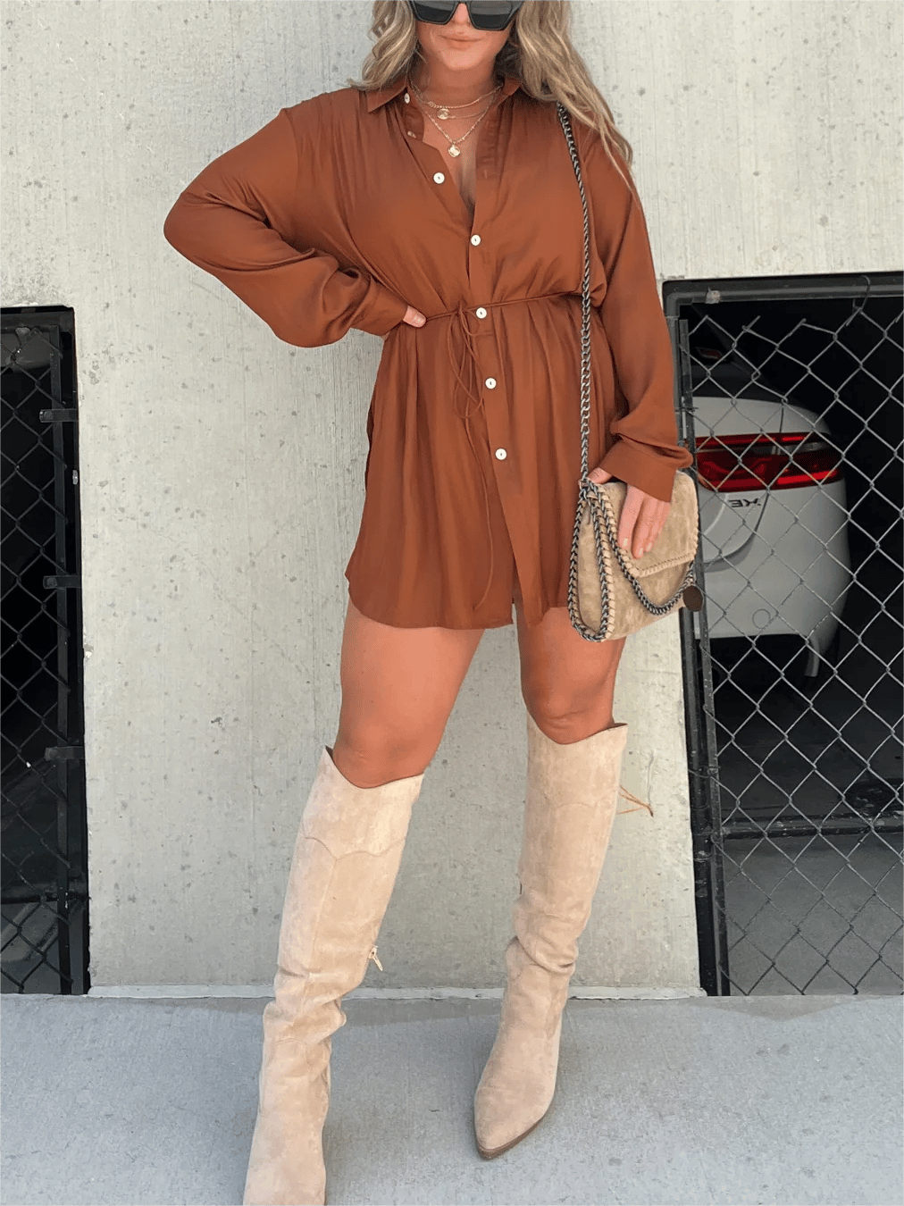 Model draagt zomerse dames jurk romperset 2-delige set jurk blouse met strikdetail hoge laarzen en handtas bruin