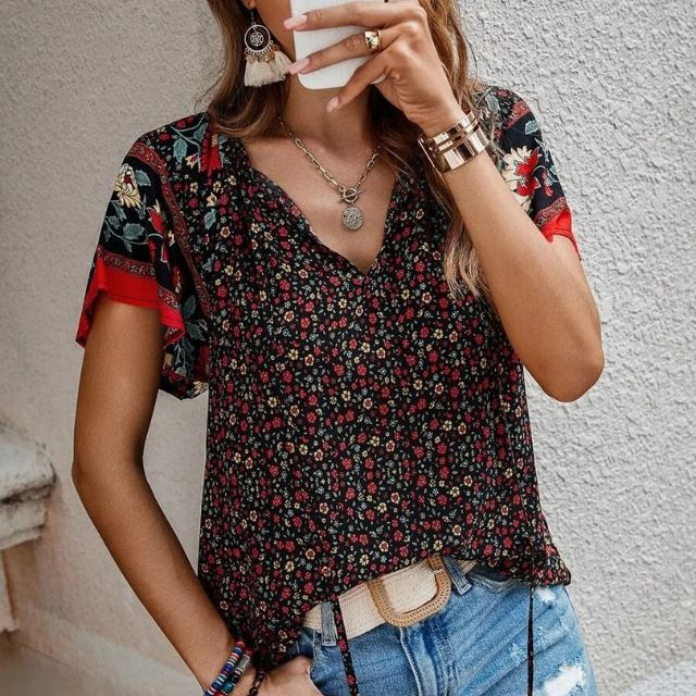 Deze blouse combineert een verfijnde V-hals met een levendige bloemenprint, ideaal voor warme dagen en zwoele avonden.