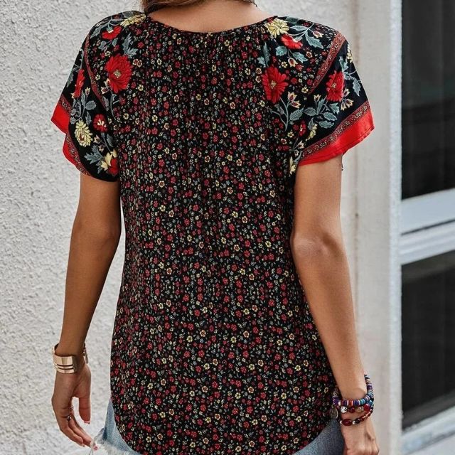 Deze blouse combineert een verfijnde V-hals met een levendige bloemenprint, ideaal voor warme dagen en zwoele avonden.