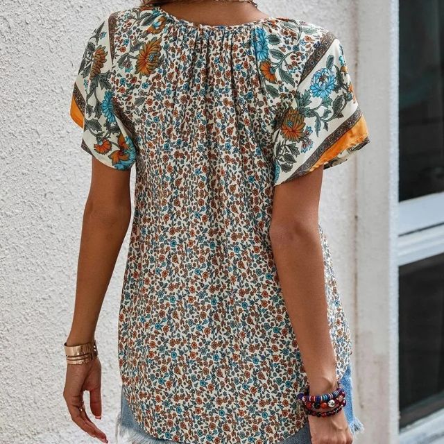 Deze blouse combineert een verfijnde V-hals met een levendige bloemenprint, ideaal voor warme dagen en zwoele avonden.