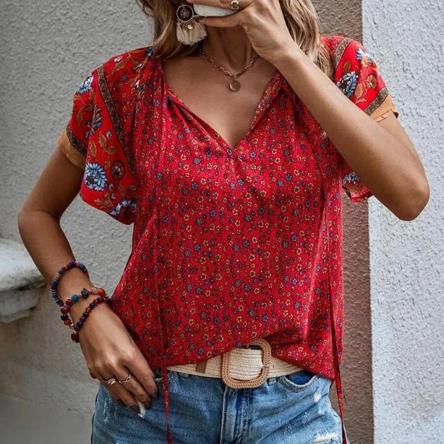 Deze blouse combineert een verfijnde V-hals met een levendige bloemenprint, ideaal voor warme dagen en zwoele avonden.