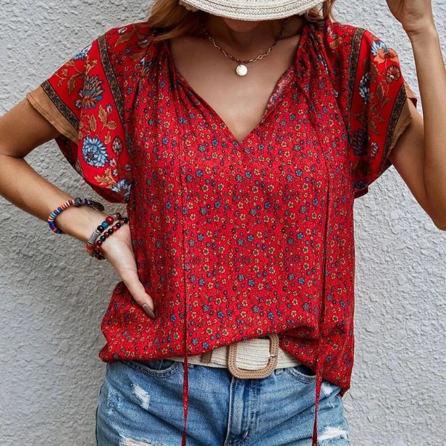 Deze blouse combineert een verfijnde V-hals met een levendige bloemenprint, ideaal voor warme dagen en zwoele avonden.