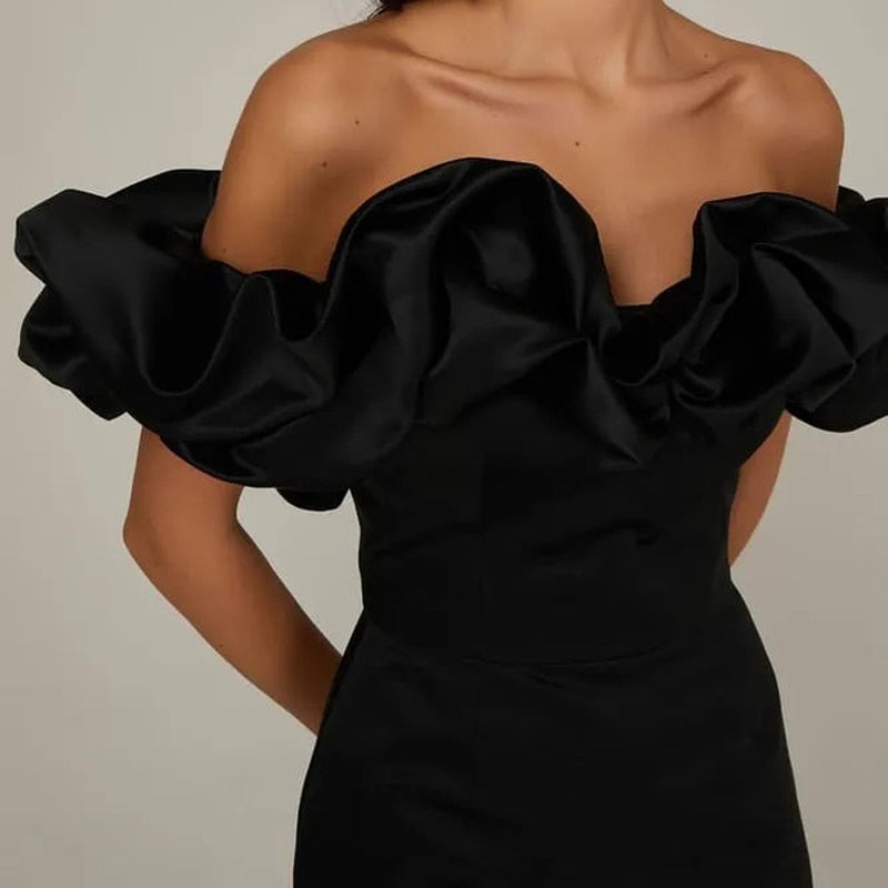 Deze adembenemende jurk combineert een trendy off shoulder ontwerp met luxe satijnen stof en elegante ruches, perfect voor zonnige dagen en zwoele avonden.