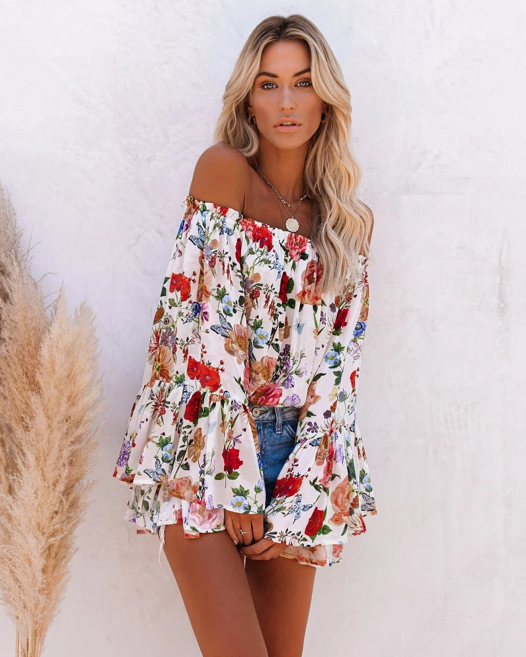 De unieke one-shoulder stijl en levendige bloemenprint maken deze blouse een echte eyecatcher voor elke zomerse gelegenheid.