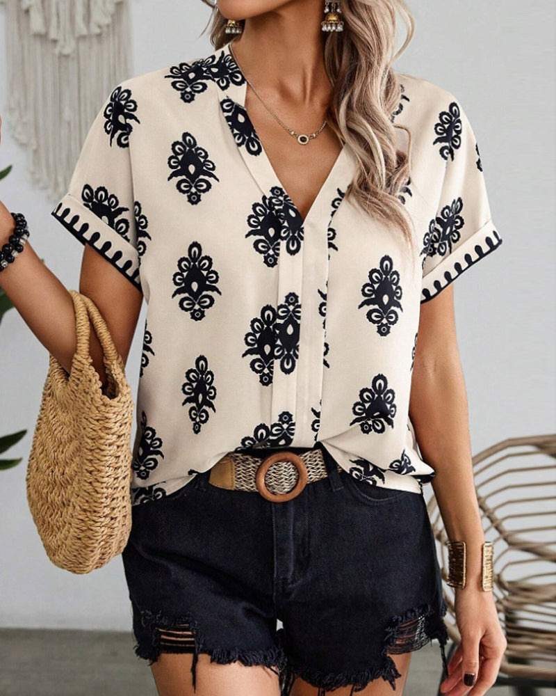 Met een trendy print en een flatterende V-hals, is deze blouse een veelzijdige aanvulling op je zomerse outfits.