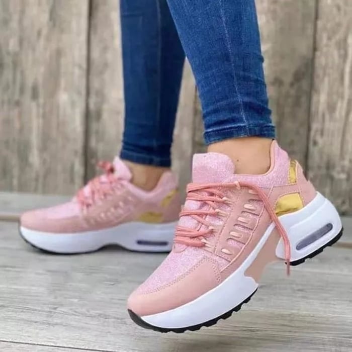 Model draagt orthopedsiche schoenen sneakers ondersteunend met witte zool sportschoenen roze