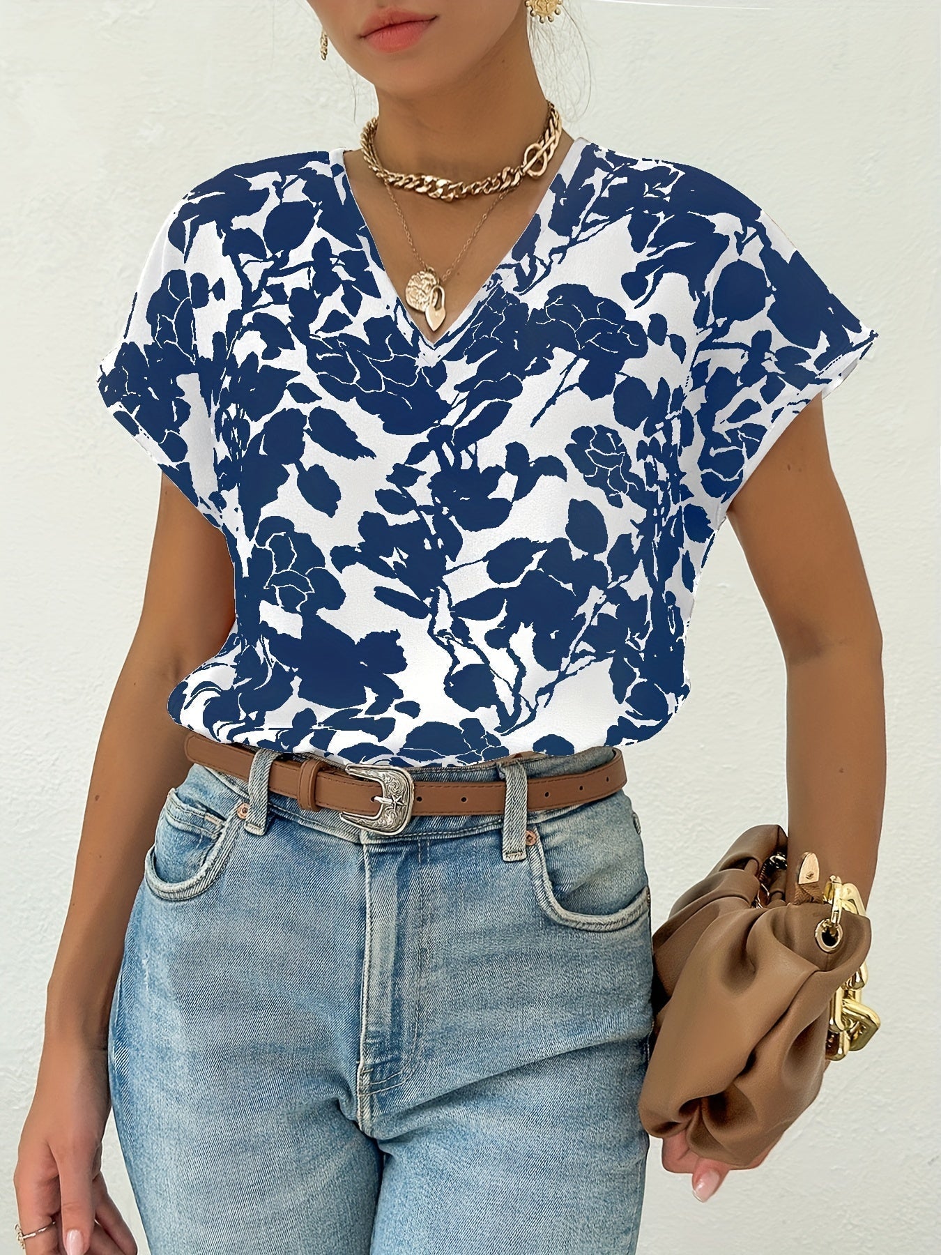 Model draagt zomer blouse met diep V-hals dames top met korte mouwen en bloemenprint blauw