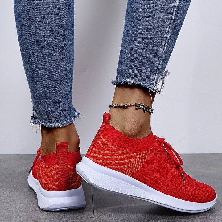 Model draagt lichtgewicht orthopedische ondersteunende dames vrouwen schoenen sneakers elastisch met witte zool en veter sluiting red