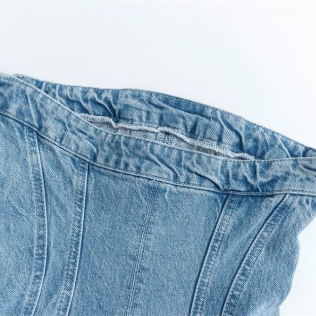 Deze spijkerrok combineert moeiteloos de klassieke stijl van denim met een eigentijds off shoulder ontwerp, waardoor het de perfecte keuze is voor casual en zomerse gelegenheden