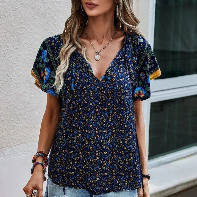 Deze blouse combineert een verfijnde V-hals met een levendige bloemenprint, ideaal voor warme dagen en zwoele avonden.