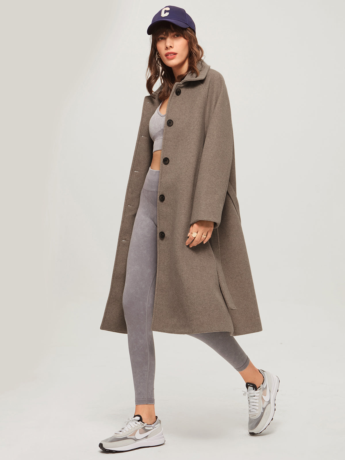 Model draagt lange cashmere trenchcoat voorjaarsjas met knoopsluiting voor en lange riem belt  khaki beige