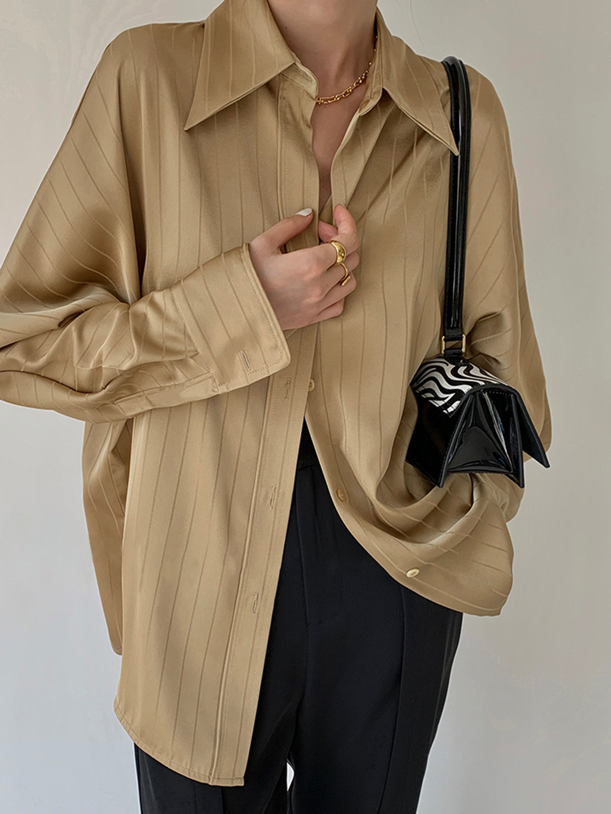 Model draagt oversized losse top blouse dames met streeppatroon casual zakelijk dunne stof zomer lente voorjaar shirt vrouwen beige