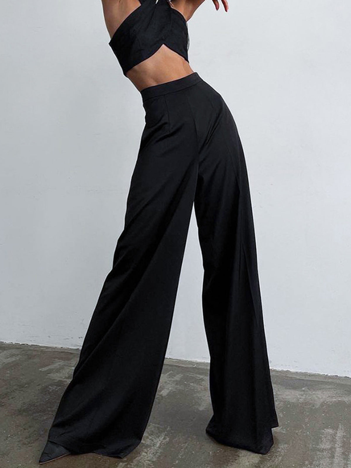 Model draagt broekpak pakbroek oversized satijnen broek pantalon met hoge taille casual zwart