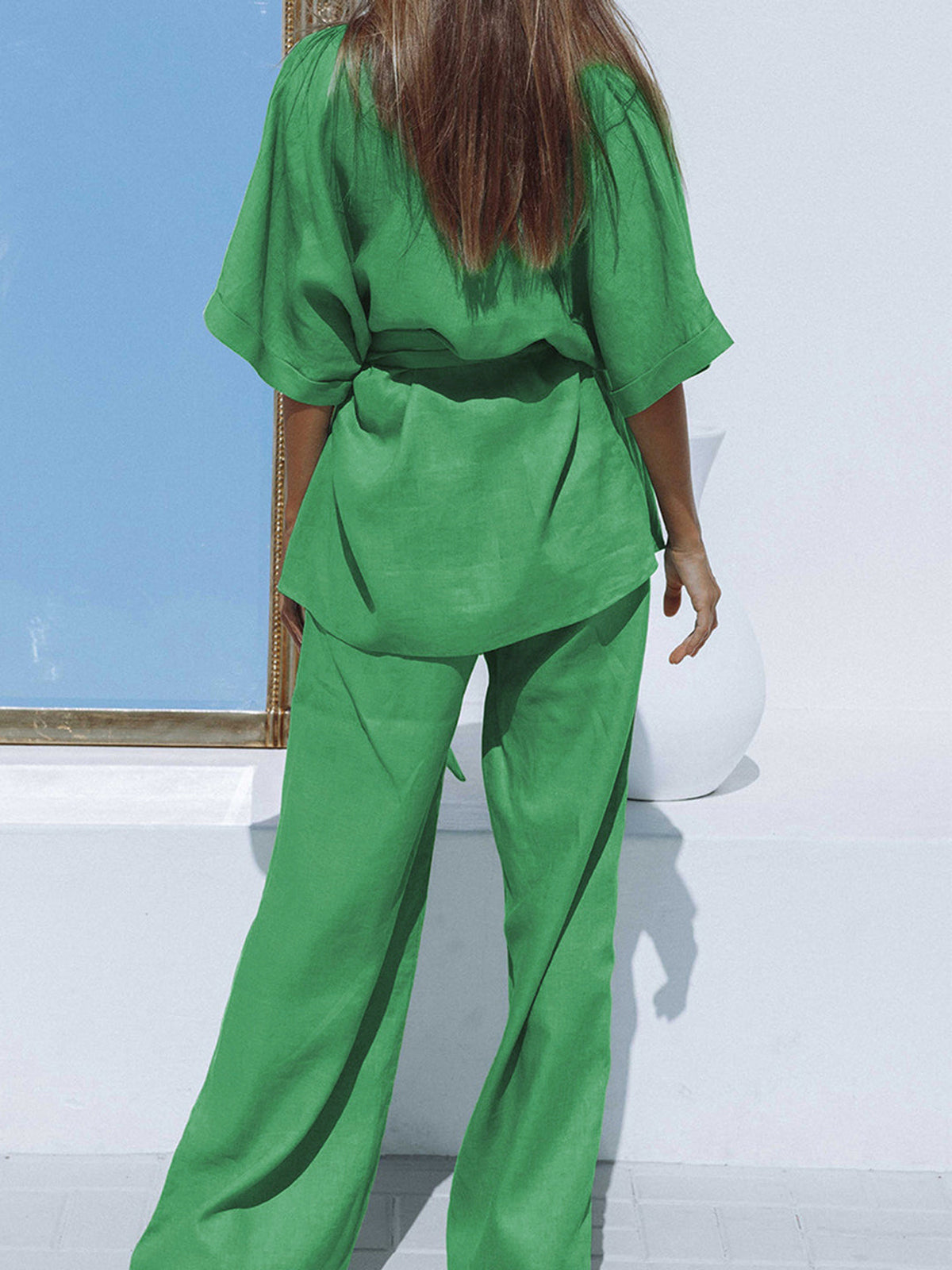 Model draagt oversized comfortabele casual 2 delige linnen set broek met hoge taille en geknoopte top groen