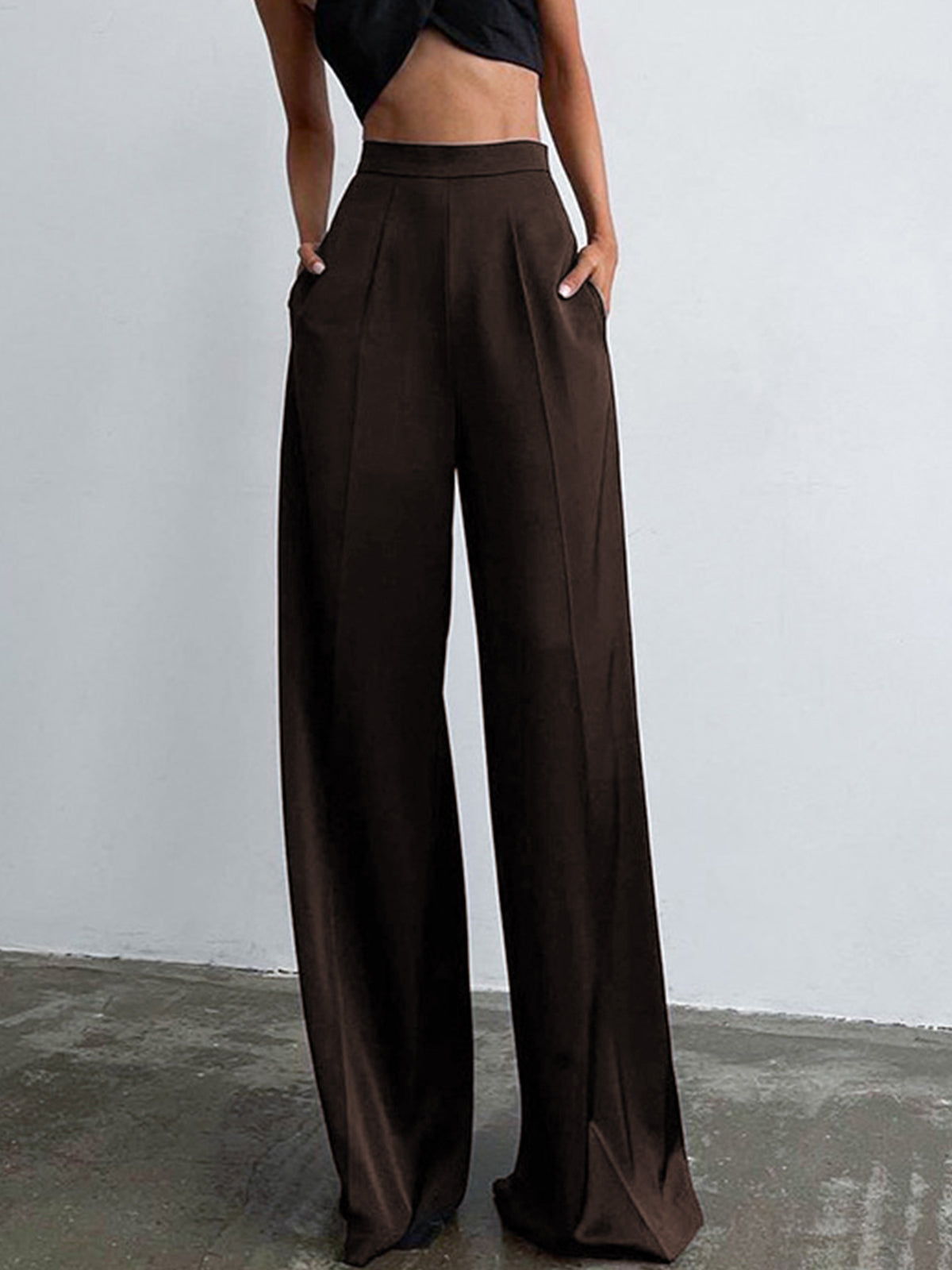 Model draagt broekpak pakbroek oversized satijnen broek pantalon met hoge taille casual bruin