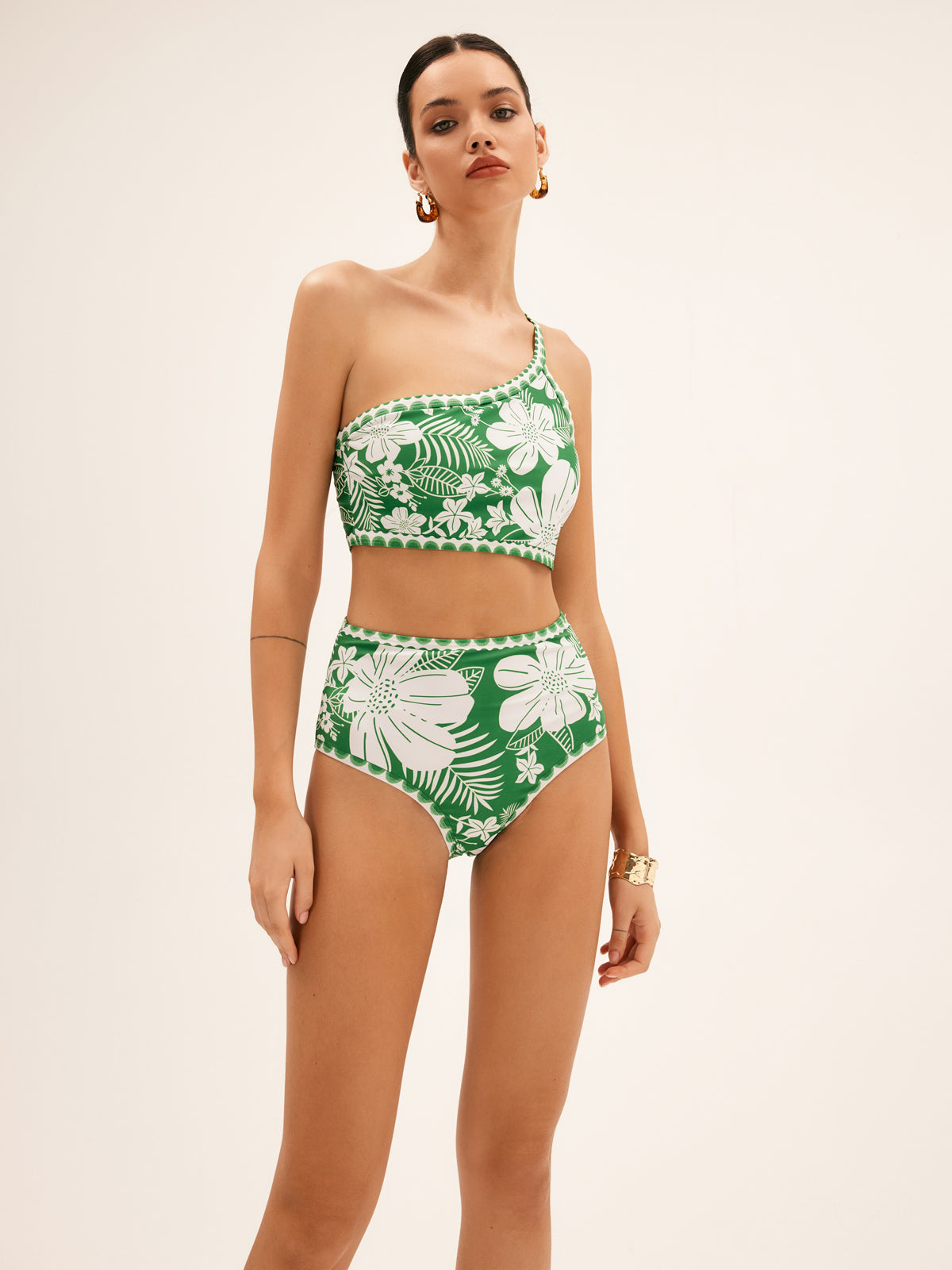 Deze trendy bikini combineert een elegante one shoulder top met een flatterende hoge taille slip, versierd met een prachtige bloemenprint.