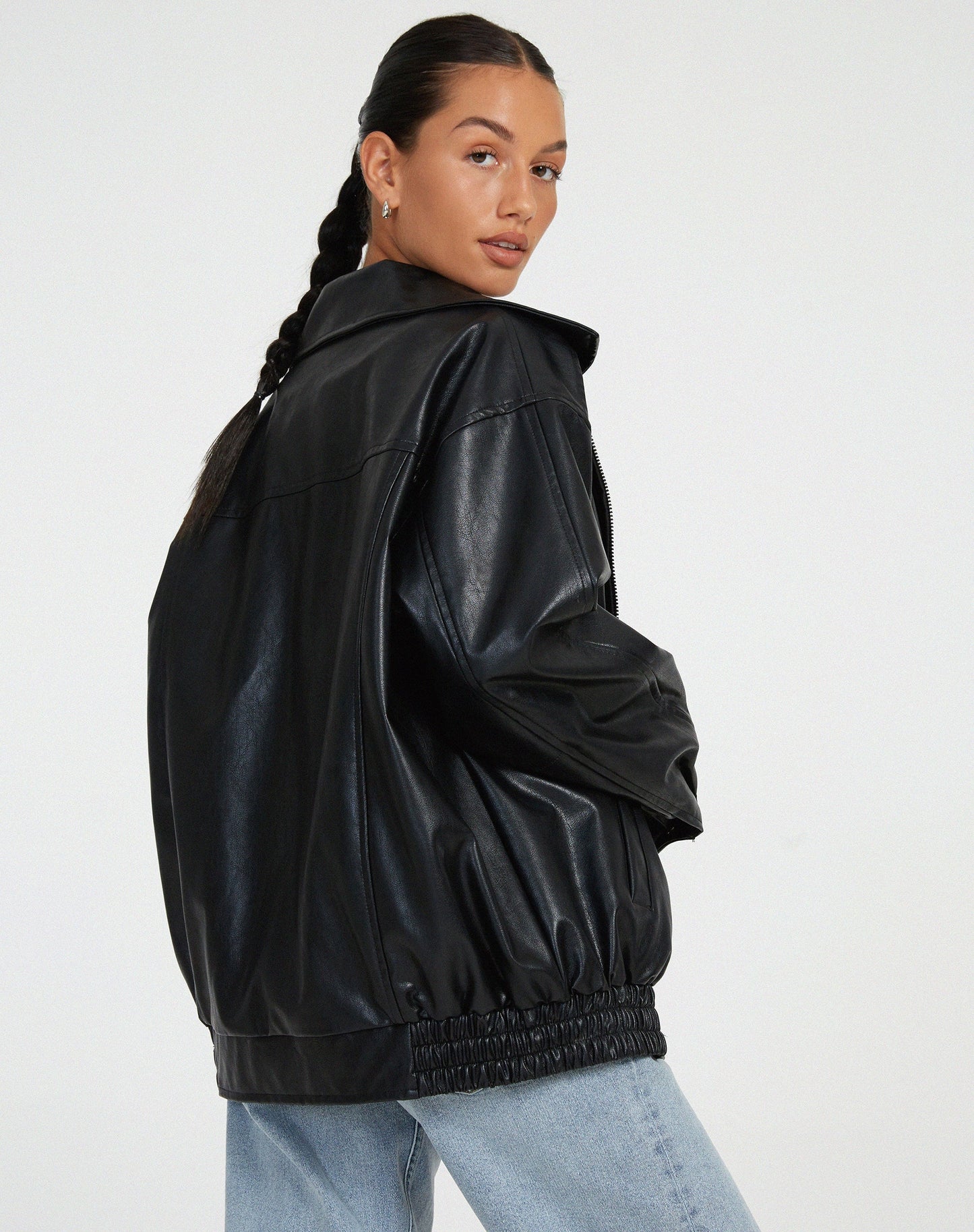 model draagt oversized losse leren jasje met rits sluiting rokje en hemd zwart leren biker jacket