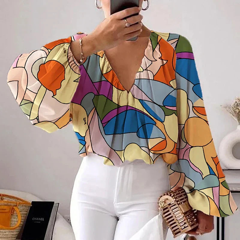 Deze blouse combineert een verfijnd bloemenpatroon met trendy gepofte mouwen, waardoor je er stijlvol uitziet tijdens de warmere maanden.