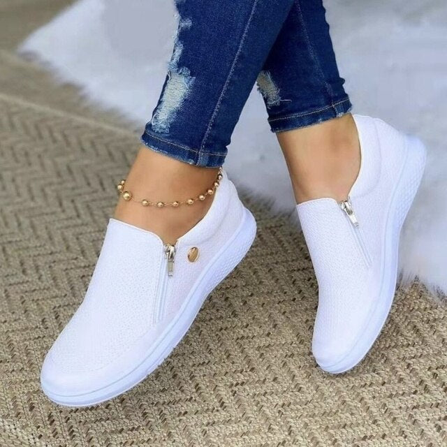 Model draagt casual sneakers schoenen ortopedische schoenen met ritssluiting instappers dames witte zool wit