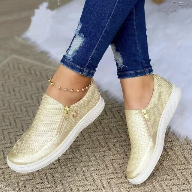 Model draagt casual sneakers schoenen ortopedische schoenen met ritssluiting instappers dames witte zool goud