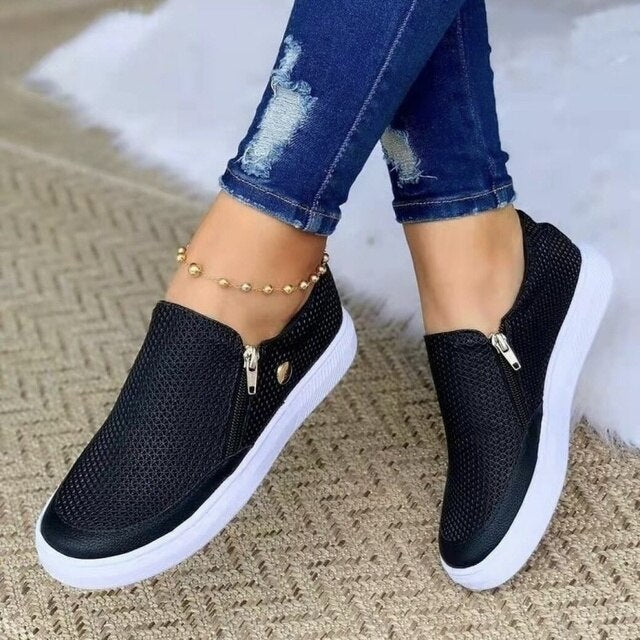 Model draagt casual sneakers schoenen ortopedische schoenen met ritssluiting instappers dames witte zool zwart