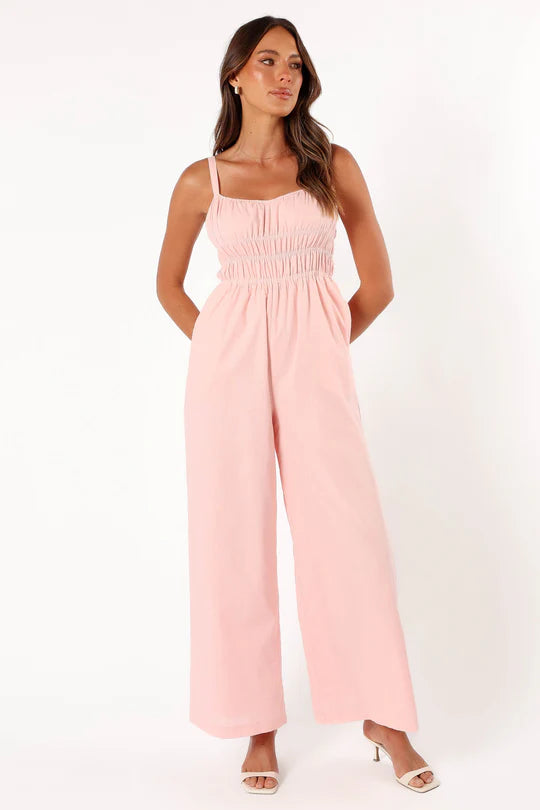 Model draagt Mouwloze Jumpsuit Met Wijde Pijpen stretch comfortabel zomer lente voorjaar outfit sandalen licht roze