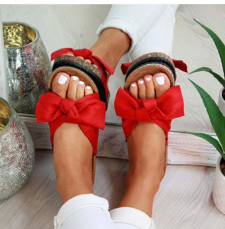 Model draagt slippers sandalen voor de zomer met strikdetail zachte band rood