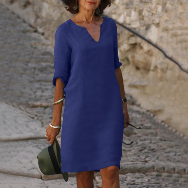 model draagt comfortabele stijlvolle linnen zomerjurk met diepe V-hals en korte mouwen 3/4 mouwen, midi jurk jurk tot de knieen elegant voor voorjaar outfit bruiloft jurk , bruiloft outfit donker blauw