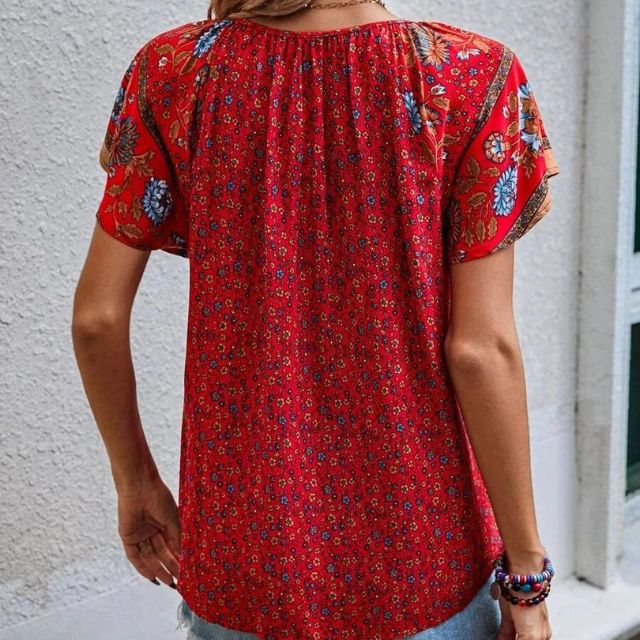 Deze blouse combineert een verfijnde V-hals met een levendige bloemenprint, ideaal voor warme dagen en zwoele avonden.