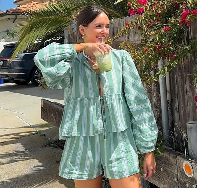 model draagt tweedelige 2 dellige short set zomerset voor dames met losse blouse met lange mouwen en losse korte broek blouse met sluiting aan de voorkant met streeppatroon strand outfit vakantie zomer