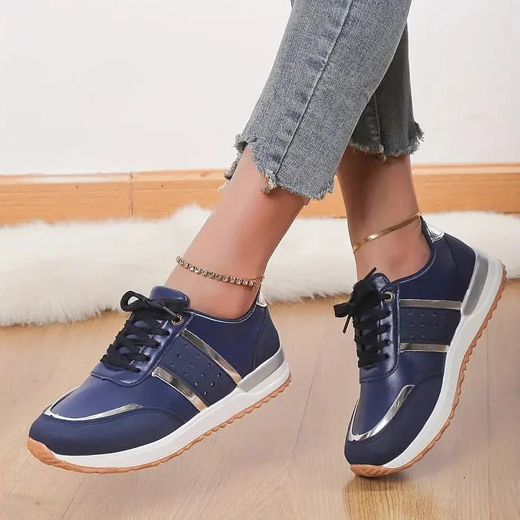 Model draagt leren orthopedische dames sneakers ondersteunende schoenen comfortabel casual witte zool leer donker blauw