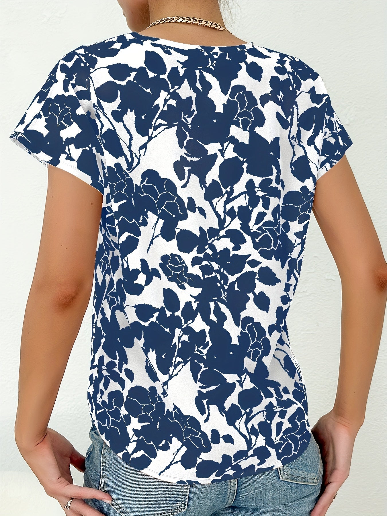 Model draagt zomer blouse met diep V-hals dames top met korte mouwen en bloemenprint blauw