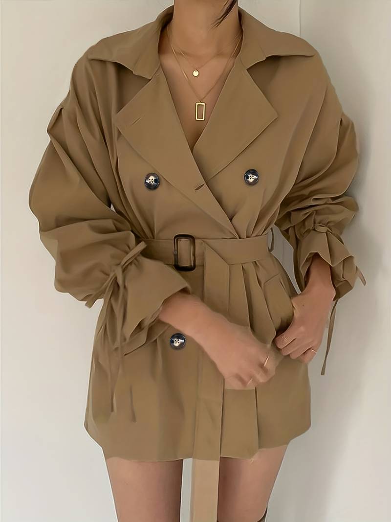 Deze stijlvolle en veelzijdige zomerjas combineert klassieke trenchcoat-elementen met een moderne, korte snit, waardoor je er elegant en modieus uitziet, zelfs tijdens koelere zomerdagen en avonden.