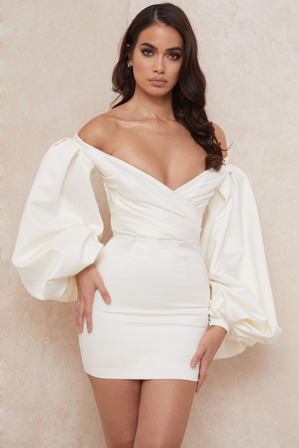 De gladde satijnen stof zorgt voor een luxueuze uitstraling, terwijl de off shoulder snit en dramatische ballonmouwen een vleugje romantiek en allure toevoegen aan je look.