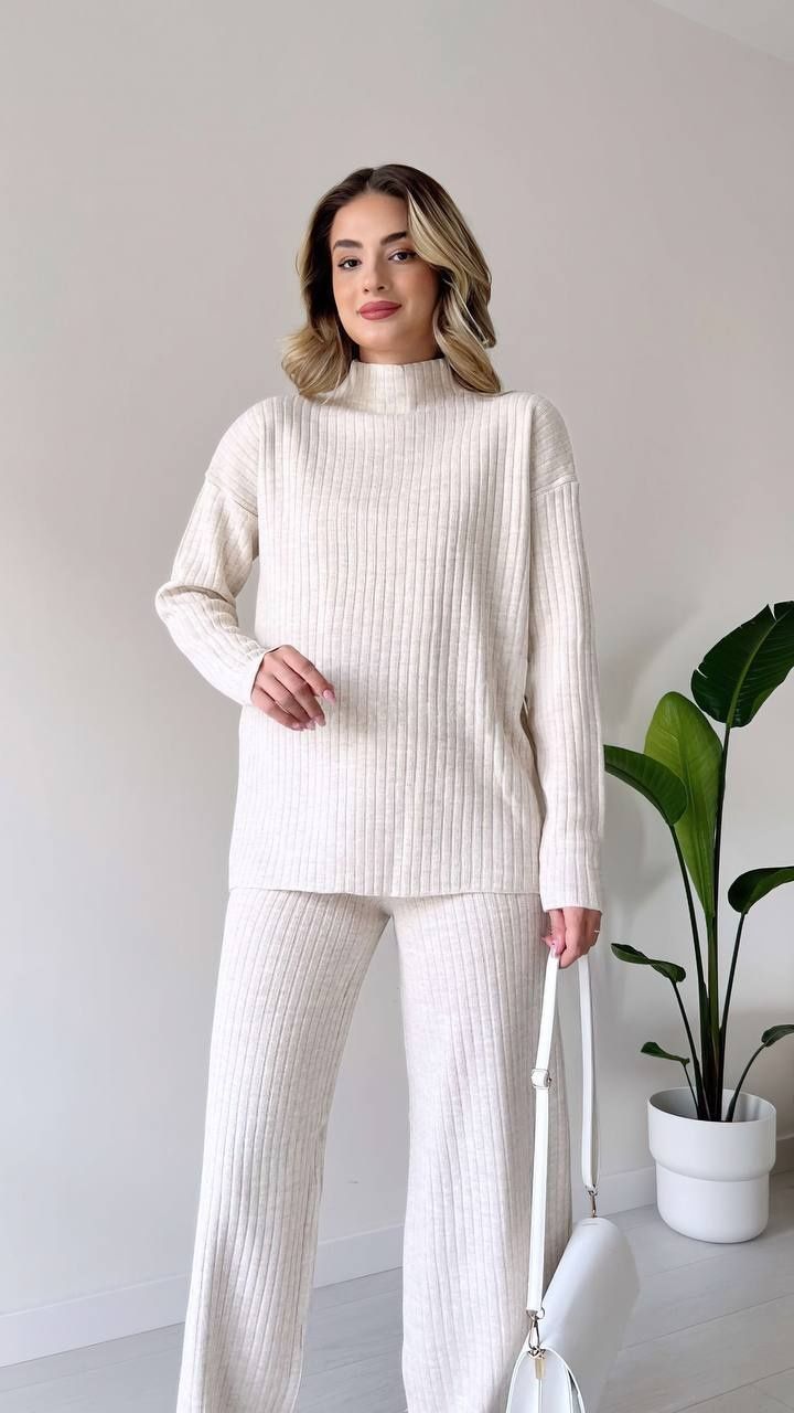 Gebreide set met coltrui en broek wit trui aan bij model