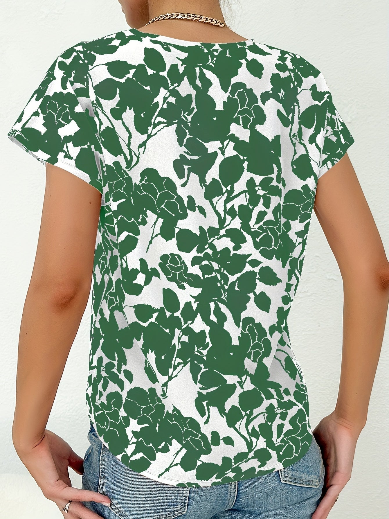 Model draagt zomer blouse met diep V-hals dames top met korte mouwen en bloemenprint groen