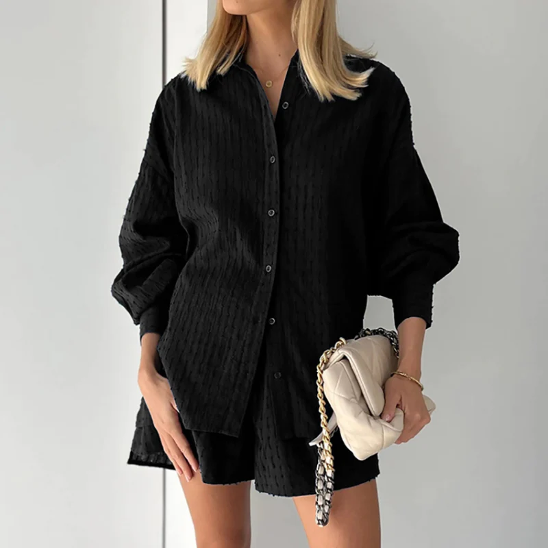 Model draagt tweedelige zomer set voor vrouwen gemaakt van katoen en linnen bestaande uit een blouse met lange mouwen en short met hoge taille losse luchtige top blouse met lantaarnmouwen en oversized fit zwart