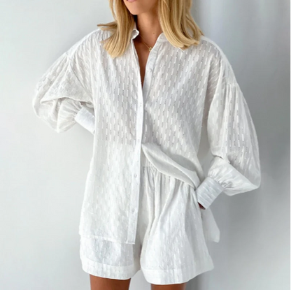 Model draagt tweedelige zomer set voor vrouwen gemaakt van katoen en linnen bestaande uit een blouse met lange mouwen en short met hoge taille losse luchtige top blouse met lantaarnmouwen en oversized fit wit