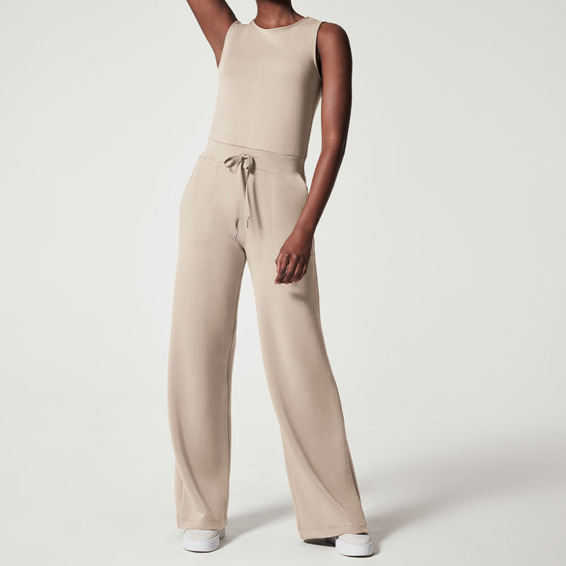 model draagt stijlvolle comfortabele jumpsuit met stretch elastische jumpsuit dames vrijetijdspak met wijde pijp en mouwloze top verstelbare striksluiting beige