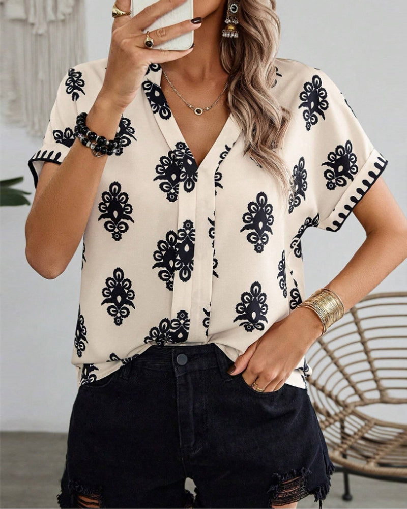 Met een trendy print en een flatterende V-hals, is deze blouse een veelzijdige aanvulling op je zomerse outfits.