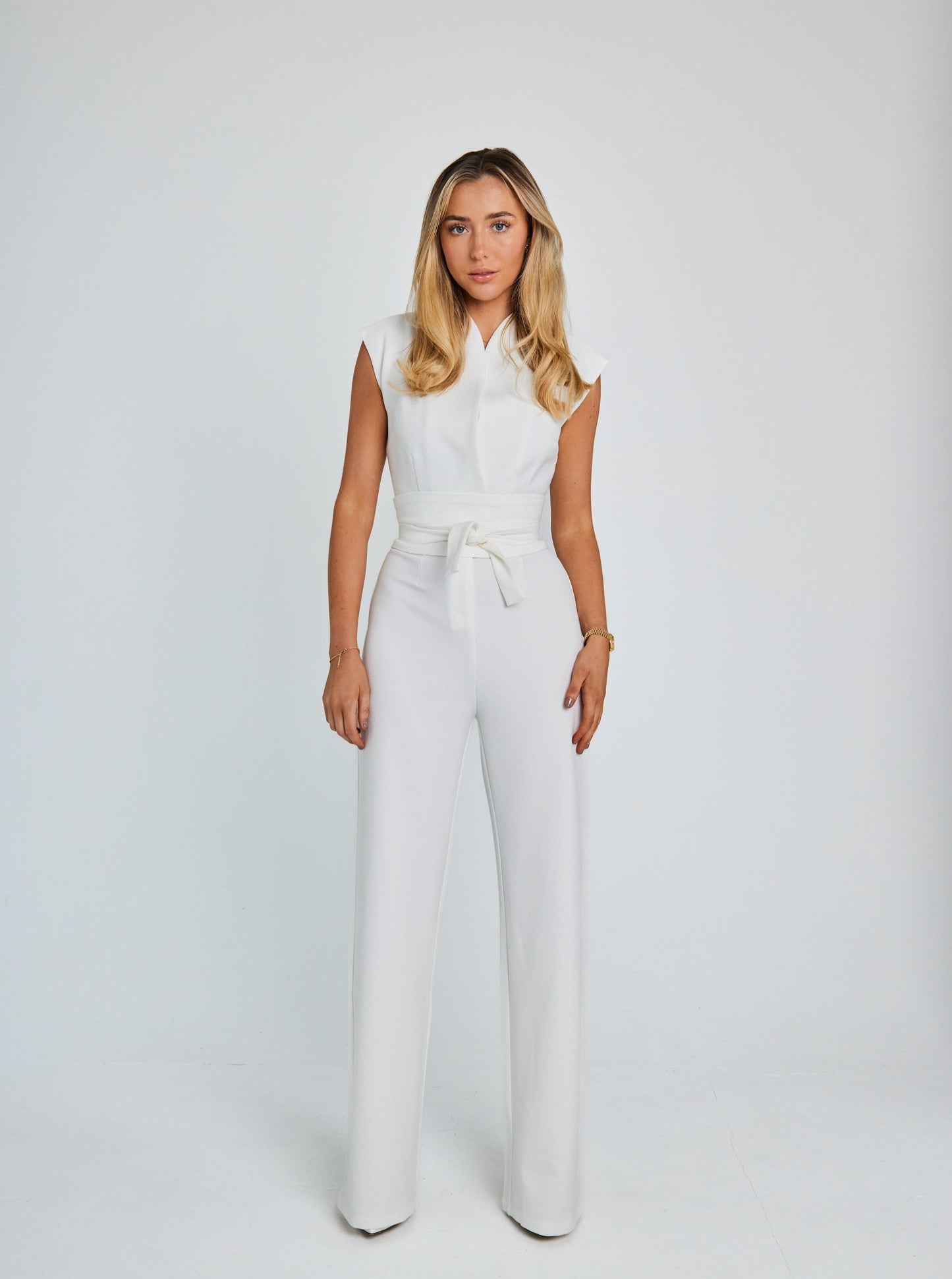 Model draagt Trendy Elegante mouwloze jumpsuit met brede taille band brede riem wijde pijp wit