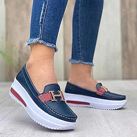 Model draagt Orthopedische loafers sneakers instappers schoenen voor dames met H logo blauw