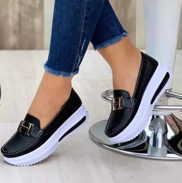 Model draagt  Orthopedische loafers sneakers instappers schoenen voor dames met H logo zwart