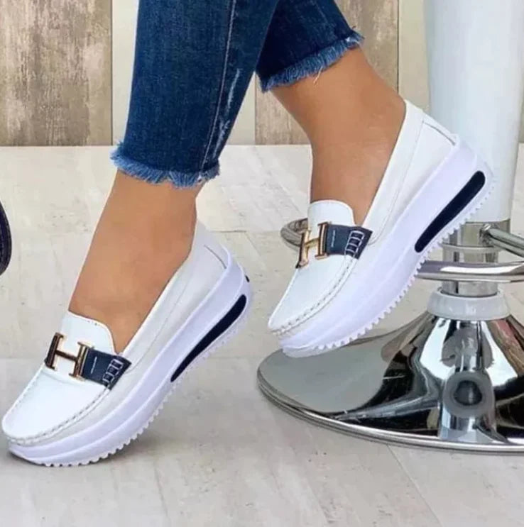 Model draagt Orthopedische loafers sneakers instappers schoenen voor dames met H logo wit