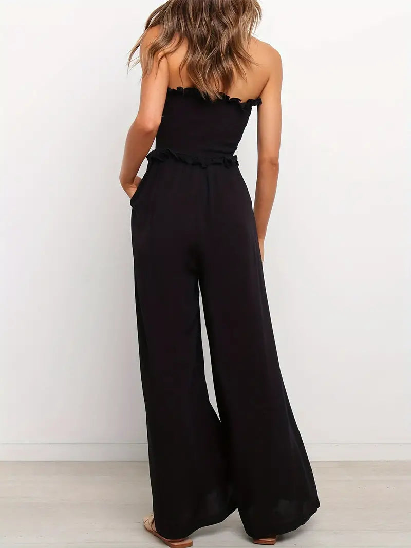 Model draagt zwarte Zwarte Cold-shoulder Jumpsuit off shlouder gebroken schouden open blote schouders broek met wijde pijp